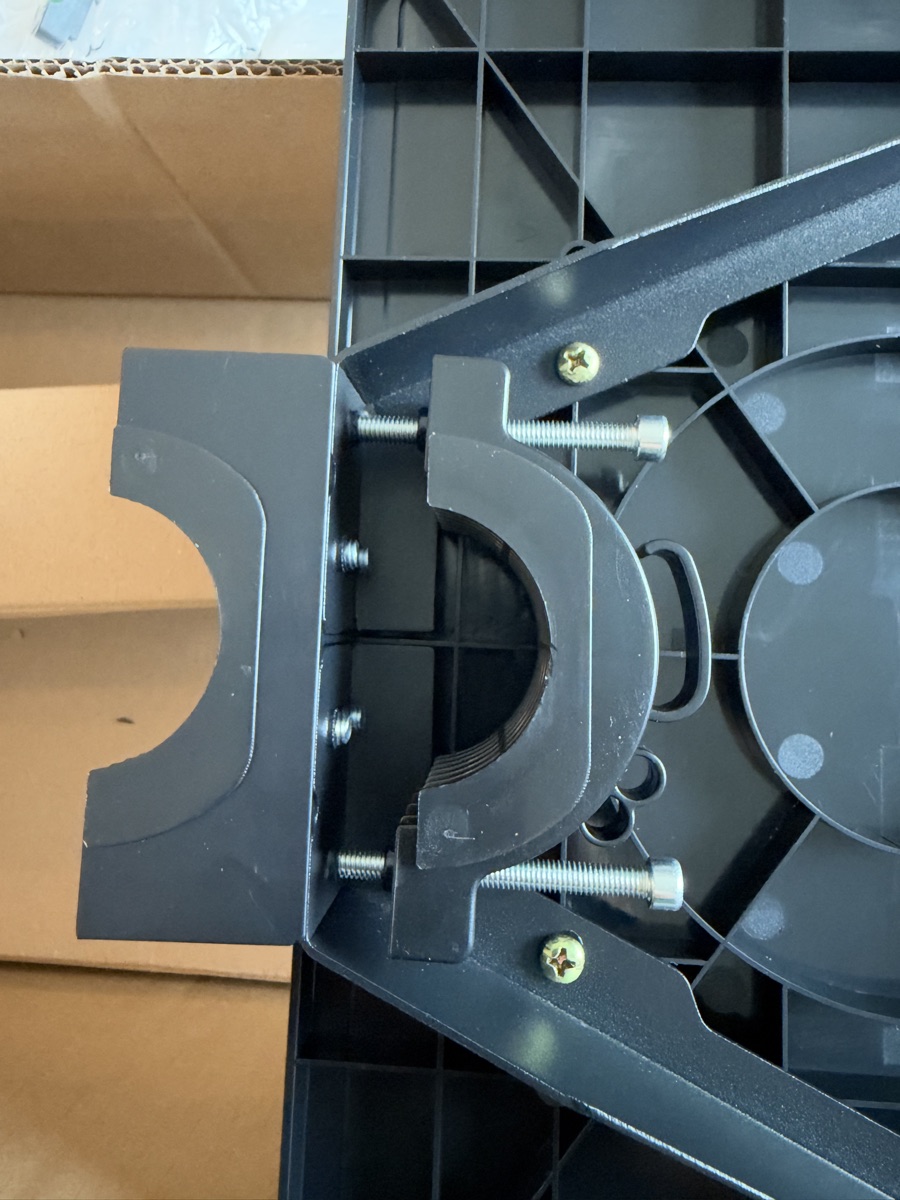 Shelf collar as shipped: rear half bolted to the shelf bracket, front half loose, two long bolts parked in the rear half